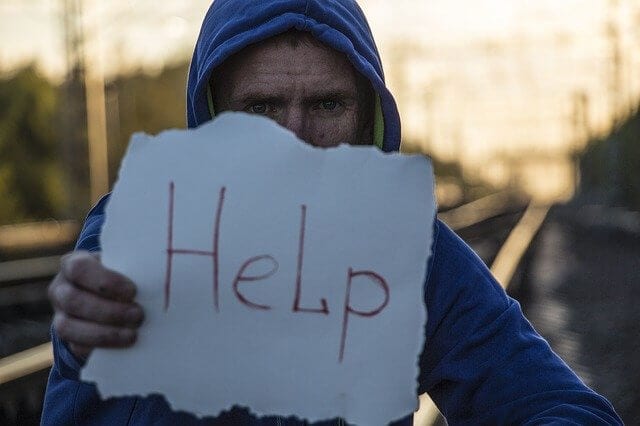 Person holding up a "Help" sign
